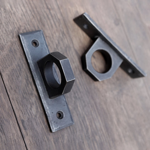 Pair of hand-forged metal hardpoints with a 2 inch ring design, mounted on a wooden surface—ideal for BDSM furniture or as industrial-style handles.